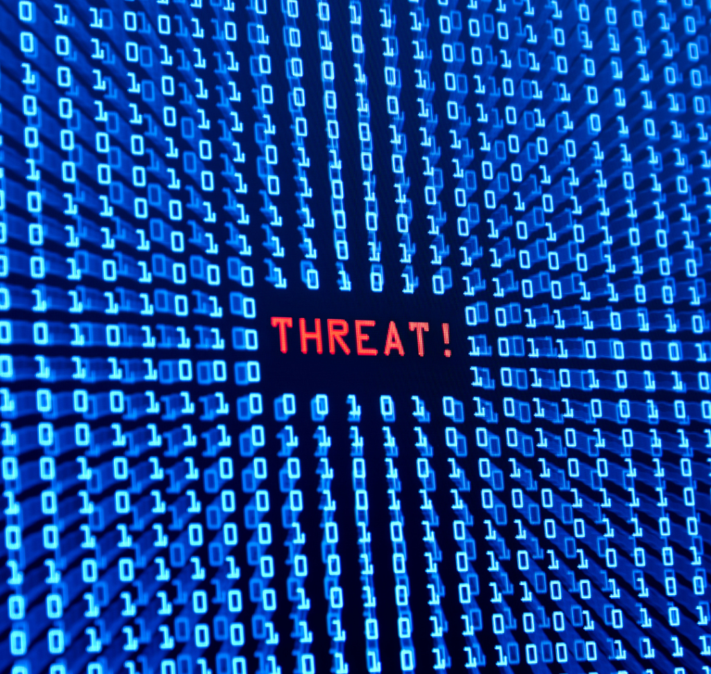 En la imagen se representa un ciberataque, con la palabra "Amenaza" en una pantalla